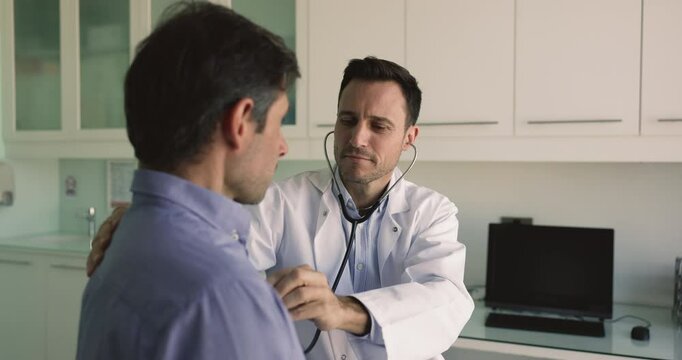 GP examining male patient heart rhythm, listen his heartbeat use stethoscope, check pulse rate, prescribe cholesterol reduction medications. Man pass cardio check-up to prevent cardiovascular disease