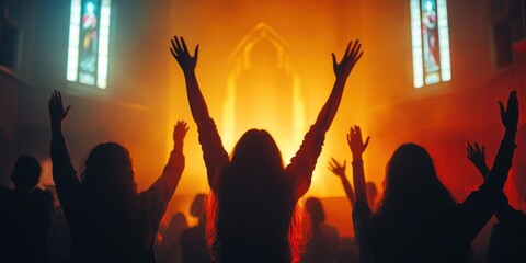 Fototapeta premium Silhouetted Figures with Raised Hands in a Church Setting
