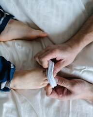 slowly pull the white socks off the children's feet.