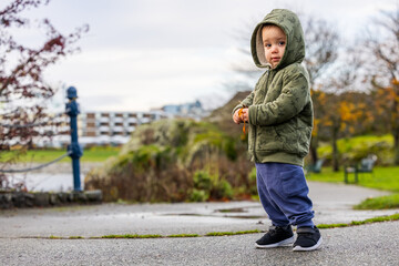 Fototapeta premium Adorable Child in Green Hoodie Playing Outdoors in Victoria