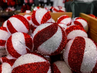 Red white colored Christmas baubles are on a store shelf during a Christmas show in a shop and are ready to be sold before the start of the holiday season