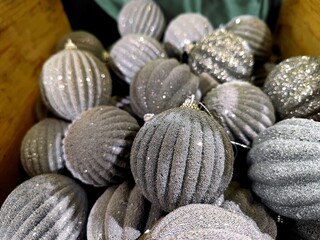 Silver white colored Christmas baubles are on a store shelf during a Christmas show in a shop and are ready to be sold before the start of the holiday season
