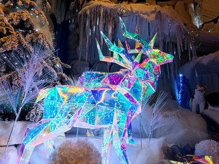 Shiny twinkly illuminated deer made of crystal are in a shop during a Christmas show