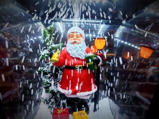 Santa Claus figure in a lantern with snow blowing up during a Christmas show in a store