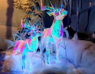 Shiny twinkly illuminated deer made of crystal are in a shop during a Christmas show
