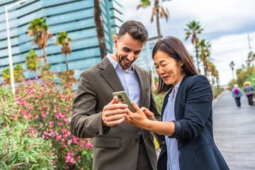 Happy multi-ethnic business people using mobile and smile at city