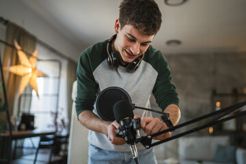 man blogger stand and prepare microphone for new video at home studio