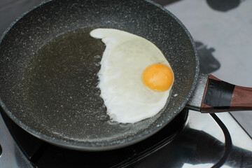 Fried egg. Close up view of the fried egg on a frying pan on gas stove, cooking egg homemade.
