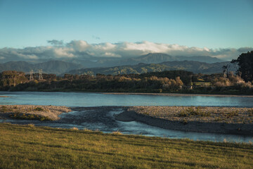 A magical view of mountains behind a large river in a remote part of New zealand.