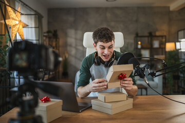 Young adult man influence open gifts while recording a live stream