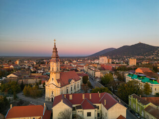 European bell tower with old red roof town in the background, Vršac, Serbia - aerial drone photo