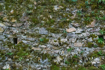 Details of old stone wall with moss with strong texture