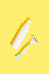 Minimalist elegance: RazorRazor and bottle of cream against a yellow backdrop with dramatic shadows