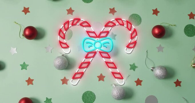 Animation of flickering christmas sugar cain over christmas decorations