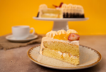 Delicious Slice of Cake Topped with Fresh Fruits and Cream Set Against a Bright Yellow Background