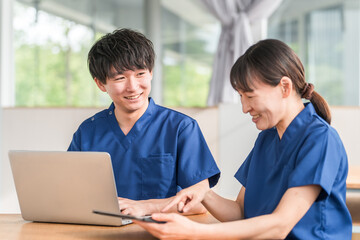 Obraz premium ミーティング・カンファレンス・申し送りを行う看護師・理学療法士・介護福祉士・医師・研修医の若い男女 