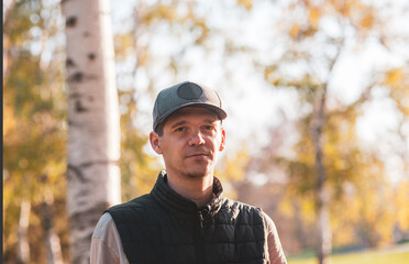 A close-up portrait of a man in a park