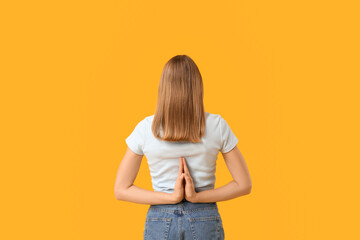 Beautiful young woman meditating on yellow background, back view. Zen concept