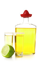 Bottle and shots of tequila with lime on white background