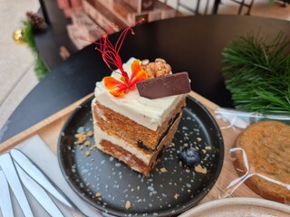 Classic carrot cake serving on the plate. Famous sweet dessert in bakery shop. Soft snack for refreshment in break time. 