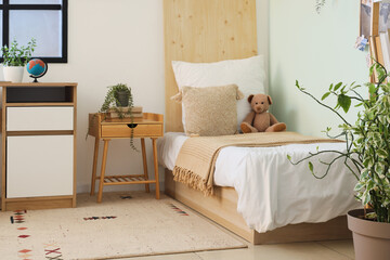 Stylish interior of modern children's room with comfortable bed and houseplants