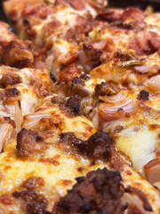 A close-up of a pizza containing mozzarella cheese, onion, chicken