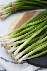Fresh green onions on white table, closeup