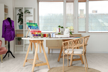 Interior of light atelier with tailor's workplace and mannequin