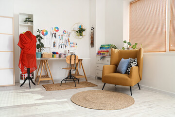 Interior of light atelier with tailor's workplace, mannequin and armchair