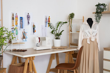 Interior of atelier with tailor's workplace, drawings and mannequin