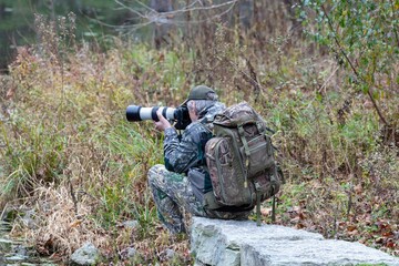 Wildlife photographer in camouflage clothing