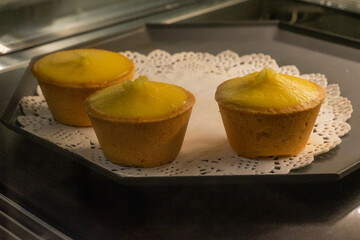 the irresistible allure of freshly baked egg tarts, their golden, flaky crusts perfectly crisp and their creamy custard filling gleaming under the light.