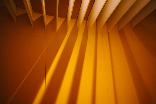 Geometric patterns of light and shadow created by architecture in warm golden hues at an urban location during the afternoon
