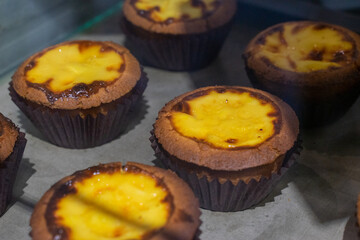 the irresistible allure of freshly baked egg tarts, their golden, flaky crusts perfectly crisp and their creamy custard filling gleaming under the light.