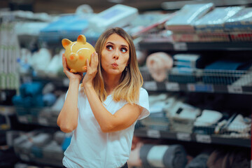 Woman Holding a Piggy Bank in a Supermarket During Sale Season. Cheerful shopper bargain hunting for inexpensive offers 
