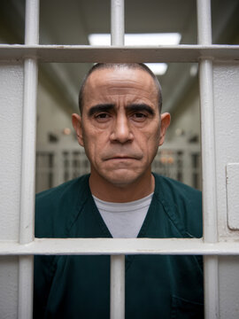 Incarcerated adult man serving a life sentence behind prison bars. Lifestyle photography in a penitentiary jail prison system.