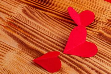 hand cut small red paper hearts on a chalkboard
