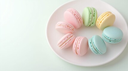 Obraz premium A colorful arrangement of pastel macarons on a white plate, showcasing a delightful assortment of flavors and textures.