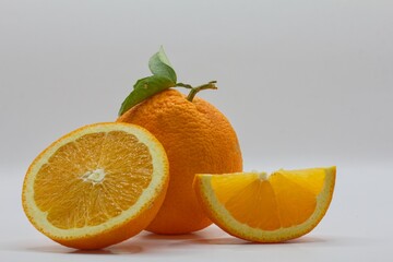 orange with green leaves, sliced ​​navel orange on isolated background