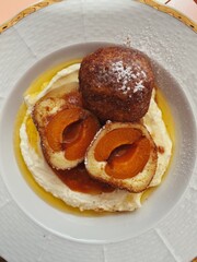 Traditional Czech apricot dumplings with creamy quark sauce, topped with walnut crumble and powdered sugar – delicious homemade dessert