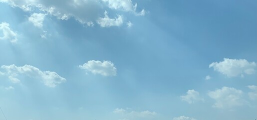 Image of blue sky with a few clouds and sunlight
