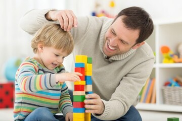 Obraz premium A father and his young son engage in a fun activity, stacking colorful blocks. The child focuses intently on the tower, while the father encourages him with a smile.