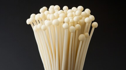 Close-Up of Exotic Enoki Mushroom Against Dark Background