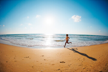 Active man jogging. Healthy lifestyle. a man runs barefoot along the beach by the sea. A young runner runs along an empty beach at dawn.
