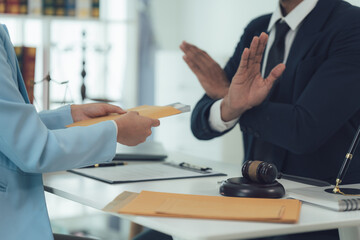 Lawyer Refusing Documents: A lawyer in a dark suit sits at a desk, with a gavel and other legal documents visible.  The lawyer refuses to accept documents from a client.