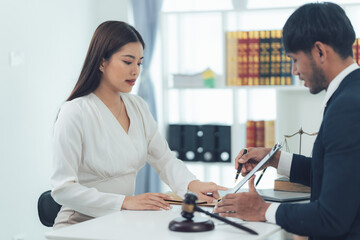 Legal Counsel: A lawyer and client discuss legal matters in a professional setting, with a gavel and legal books adding to the scene's authority. The image conveys a sense of trust, expertise.