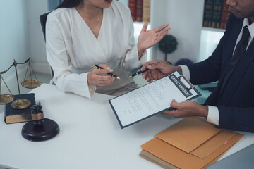 Legal Consultation:  A lawyer and client meticulously review a document, emphasizing the importance of legal advice and representation.  The scene suggests a serious and focused discussion.