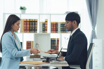 Legal Consultation:  A serious yet professional exchange between a male and female lawyer in a modern office setting.  The image conveys trust, expertise, and legal proceedings. 