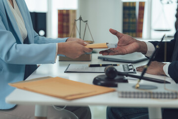 Legal Transaction:  A close-up shot of a serious and formal exchange of documents between a lawyer...
