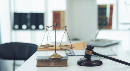 Scales of Justice: A close-up shot of a gavel, scales of justice, and a book on a lawyer's desk....